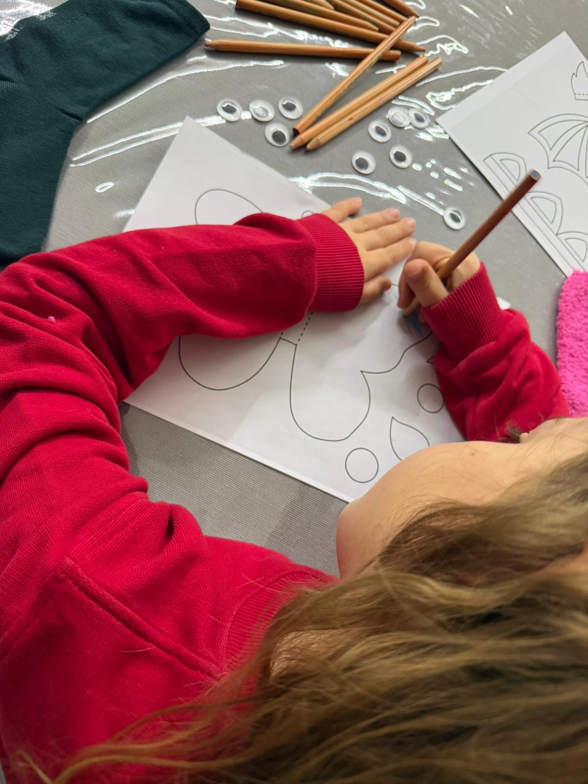 Bambina che colora il pupazzo